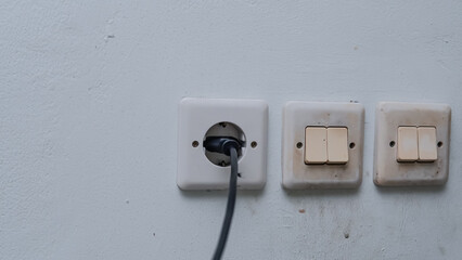 An black adapter are installed in a wall socket