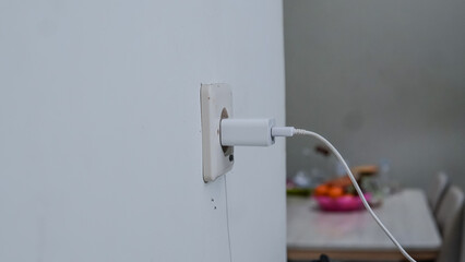 An adapter and charger cable to charge the cellphone are installed in a wall socket