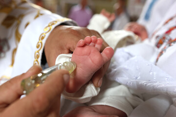 Fototapeta premium The priest performs the rite of baptism and anointing.