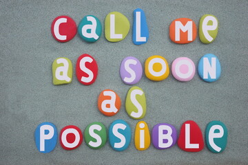 Call me as soon as possible, creative message composed with hand painted stone letters over green sand