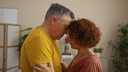 Middle-aged couple embracing tenderly in a cozy living room setting showing affection and connection at home