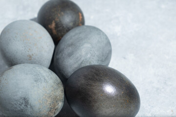 Close-up of gray and black Easter eggs on a textured surface