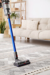 Cleaning with wireless handheld vacuum cleaner indoors, closeup © New Africa