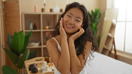 Woman smiling in spa room showcasing wellness and beauty in an indoor setting with asian decor and relaxing atmosphere