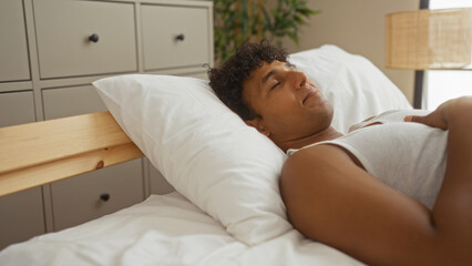 Young man sleeping comfortably on a bed in a cozy bedroom, showcasing an interior home setting with soft lighting and peaceful ambiance.