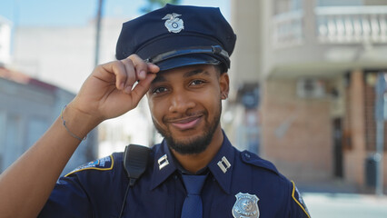 African american male police officer smiling in urban outdoor setting