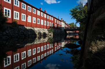 V&auml;ster&aring;s old town, Swedish style red houses with reflection in Svartan River (Svart&aring;n) in sunny day, Sweden