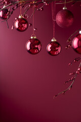  Burgundy christmas vertical background with wine colored christmas decorations and crystals hanging on fir branches with red berries on rich burgundy background with copy space