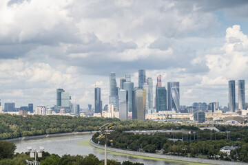 A panoramic view showcases Luzhniki Park alongside the modern skyline of Moscow City, highlighting lush greenery and dynamic architecture