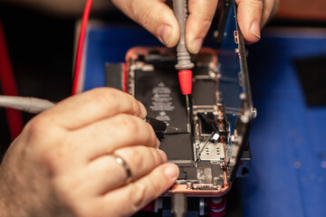 Repairing a smartphone battery with precision tools to ensure optimal performance during a busy afternoon at a tech repair shop