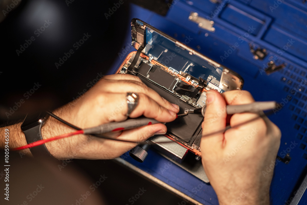 Poster technician performing smartphone battery repair with specialized tools on a workbench in a well-lit 