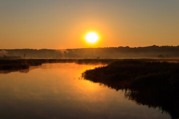 View of river in the mist at sunrise. Fog over river at morning