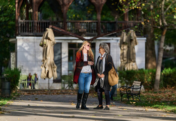 Obraz premium Autumn Walk: A Mother and Daughter Share Love and Support in Natures Embrace.