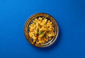Loaded Cheese Fries with Parmesan and Parsley served in plate isolated on blue background top view of fast food