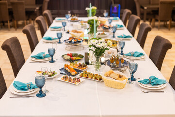 Table with food. Banquet hall. The waiter sets the table.