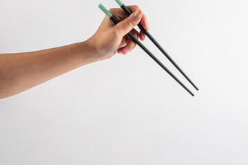 Black chopsticks for rice and hand on a white background