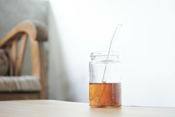 A glass of delicious tea is placed on the table with a backdrop of plants and chairs