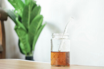 A glass of delicious tea is placed on the table with a backdrop of plants and chairs