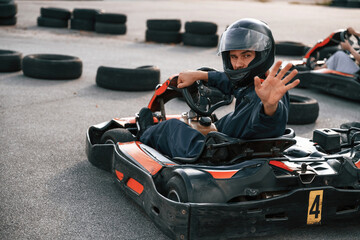 Handsome positive man is outdoors, kart racing conception