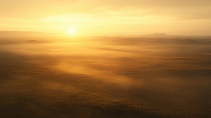 Fototapeta premium A sunrise over the plains, with mist rising from the ground and the light casting a golden glow across the landscape. -