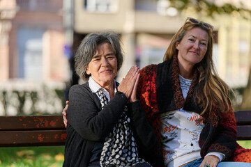 Embracing Generations: A Daughter's Love and Support for Her Senior Mother on a Sunny Day in the Park