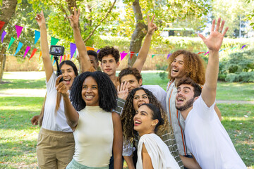 Group of friends taking selfie in park with action camera