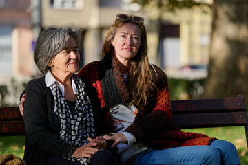 Embracing Generations: A Daughter's Love and Support for Her Senior Mother on a Sunny Day in the Park