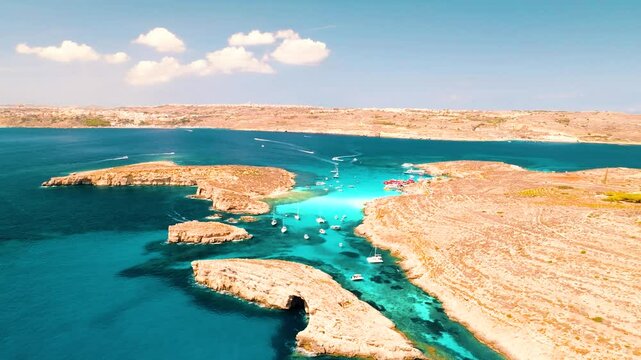 Aerial view of Comino Island, Gozo, and the Blue Lagoon in Malta during a busy summer afternoon. 