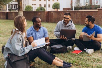 Diverse Group of Students Collaborating Outdoors on College Campus Lawn