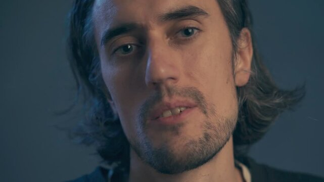 a young man with long hair, large expressive eyes, European appearance, looks in bewilderment from a high place, slightly disdainfully sighs sadly, knowingly, shakes his head negatively