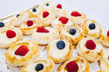 Plateau de desserts avec choux à la crème aux fruits rouge fraise framboise et myrtille