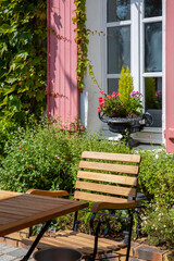 Plante fleurie en pot devant la fa&ccedil;ade d'une jolie maison en France.