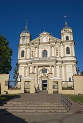 Obraz premium Vilnius, Lithuania - Sep 21, 2024: St. Church of Apostles Peter and Paul. People walking in Vilnius. Streets, buildings. Lifestyle in the urban area. Sunny summer day. Selective focus