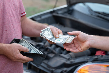 US citizen spending last money for fixing car. Car owner paying service mechanic for fixing his...