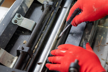 Professional carpenter loosen nut to change knives in his wood sanding cutting machine. Woodworking, maintenance of tools to make high quality wooden furniture