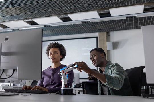 Coworkers programming a robotic arm