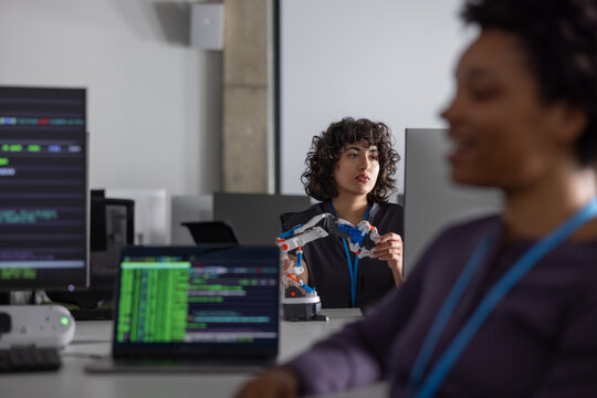 Female engineer working on programming a robotic arm
