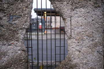 Hole in Broken Berlin wall and walking person against