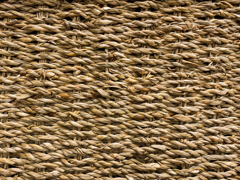 Woven straw mat texture background, presenting a natural, rustic aesthetic with intricate interlocking fibers. Great for eco-friendly product packaging and interior decor