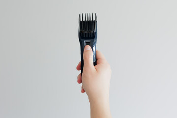 Man's hand holding electric hair cut machine on white