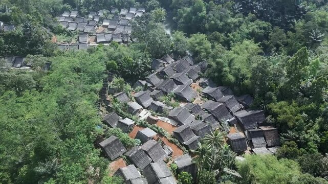 The Baduy tribe's houses seen from above, surrounded by green forests and flowing rivers, provide a glimpse into their daily life which is simple and harmonious with nature.