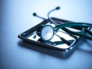 Stethoscope on a metal tray in a clinical setting for healthcare and medical tests.