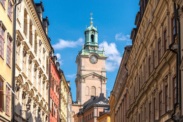 Historic Storkyrkan in Stockholm, Sweden, with its bell tower and clock, surrounded by traditional buildings.