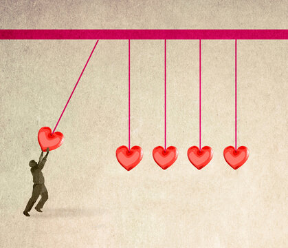 Illustration of man starting oversized Newtons cradle composed of hearts