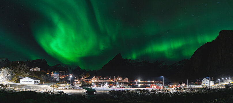 Night view of northern lights over fishing port in Lofoten Islands, Norway.
