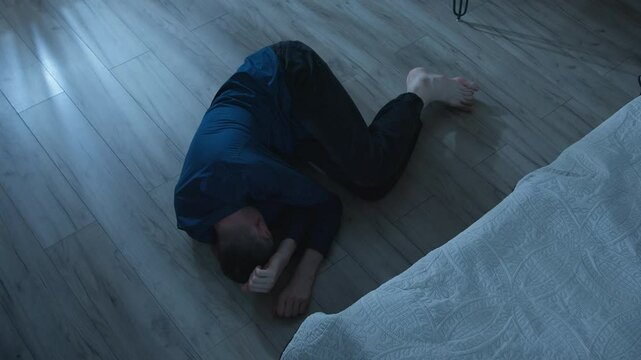 Desperate man lying on the floor in the room. Mental health, stress. Concept of depression, loneliness and problems.