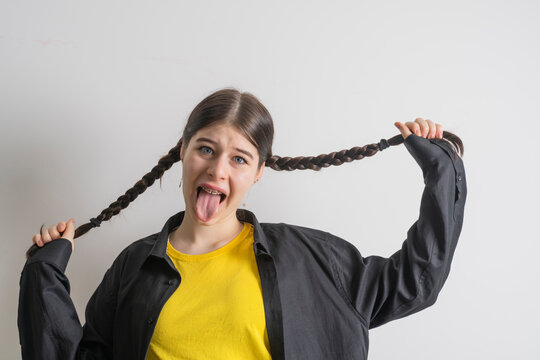Teenager girl with braces having fun at home, showing self-love and individuality.
