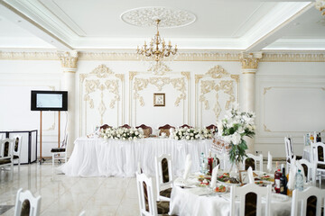Festive hall in the restaurant with tables and chairs.