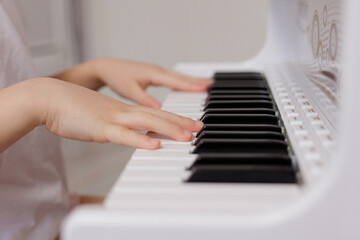 Fototapeta premium Close up of little child's hands playing the piano