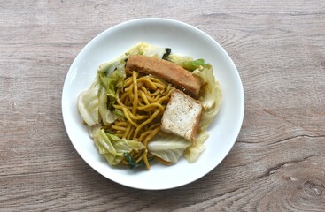 fried yakisoba noodles and cabbage with carrot topping tofu vegetarian food on plate